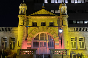The front of KEMH lit up at night